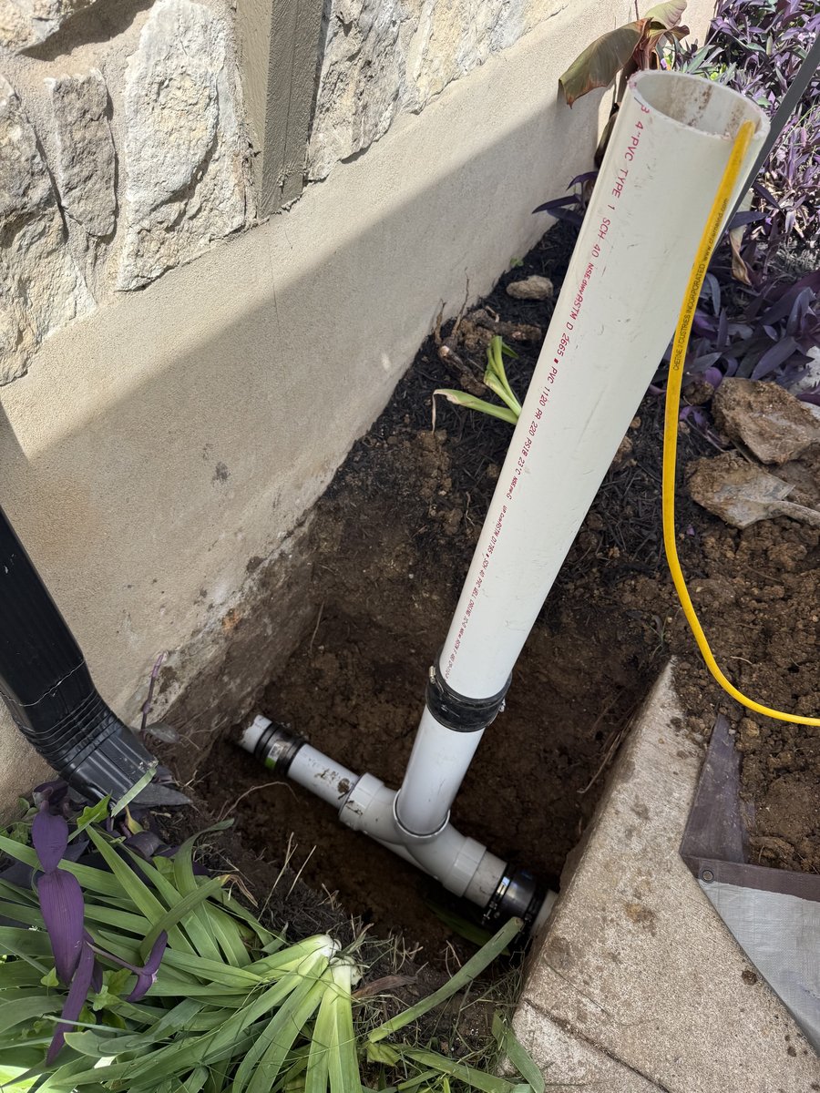 Sewer cleanout installed beside a home foundation