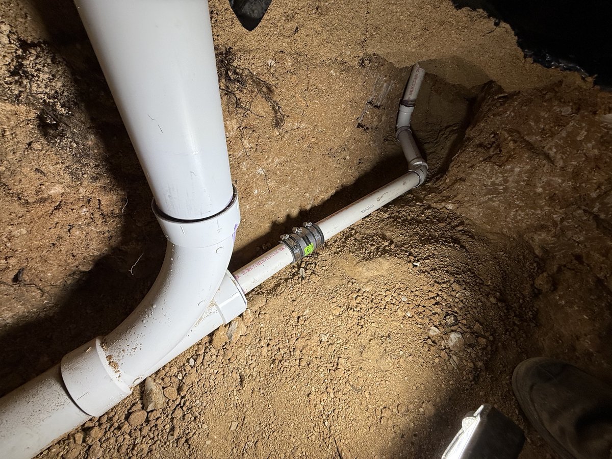 Underground PVC sewer pipe repair in an open trench